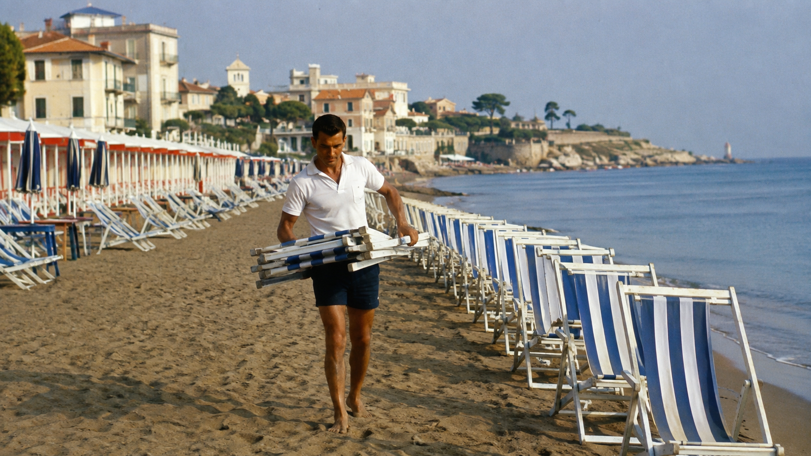 Bagnino arranging striped beach chairs